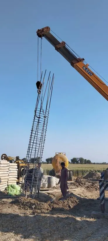 Crane setting a pile cage into the bore